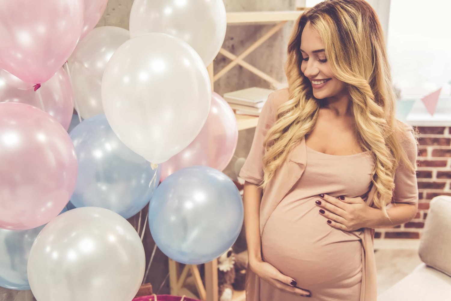 surrogate mother at baby shower smiling at balloons